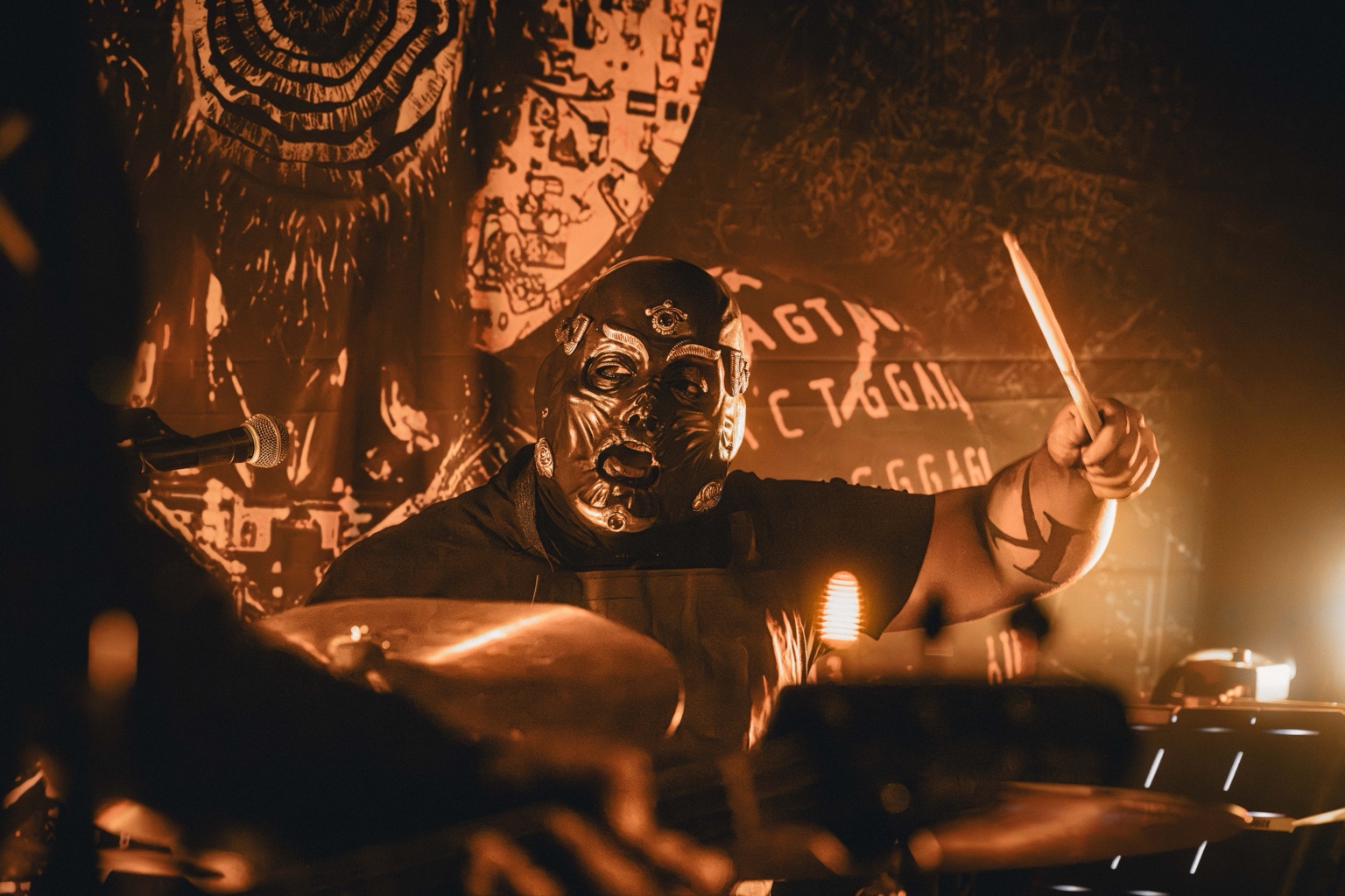 KING 810 / 2026 — Drummer performing under amber stage lights
